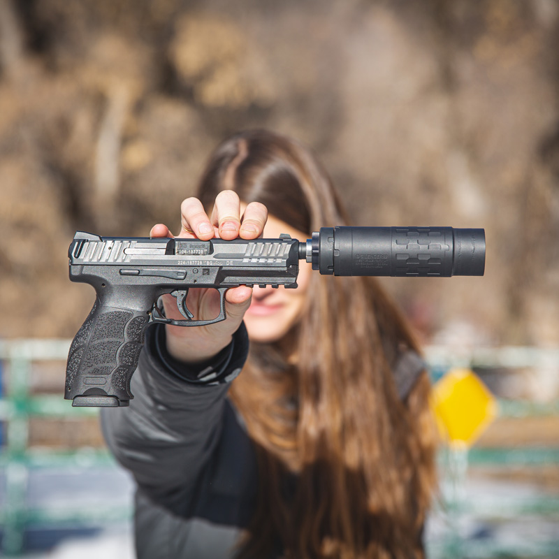 Woman holding an Omega 36M Short configuration on an HK VP9 out toward the camera- the image is a good match for the article discussing Missouri suppressor laws.