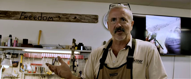 American Gun image of riflesmith Terry Cross with Freedom sign in shop