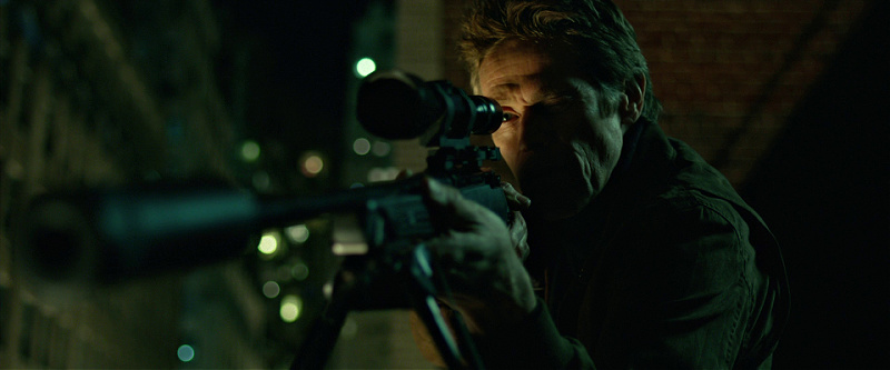 John Wick looks through scope of a suppressed rifle