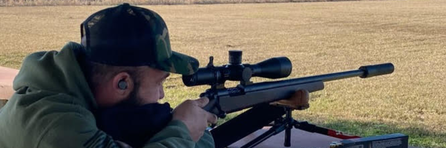 Chase Glenn aiming suppressed rifle