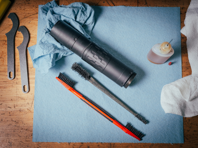 SilencerCo Omega 36M, a fully welded suppressor, on a table with cleaning supplies.