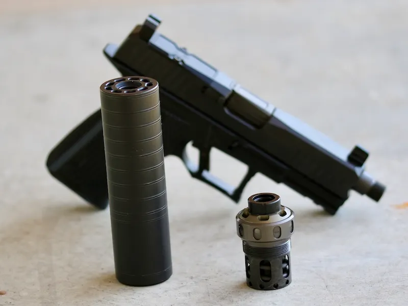 handgun in background, Spectre 9 suppressor and Nielsen device in foreground.