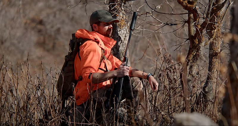 hunter with rifle suppressed with SilencerCo Harvester Evo