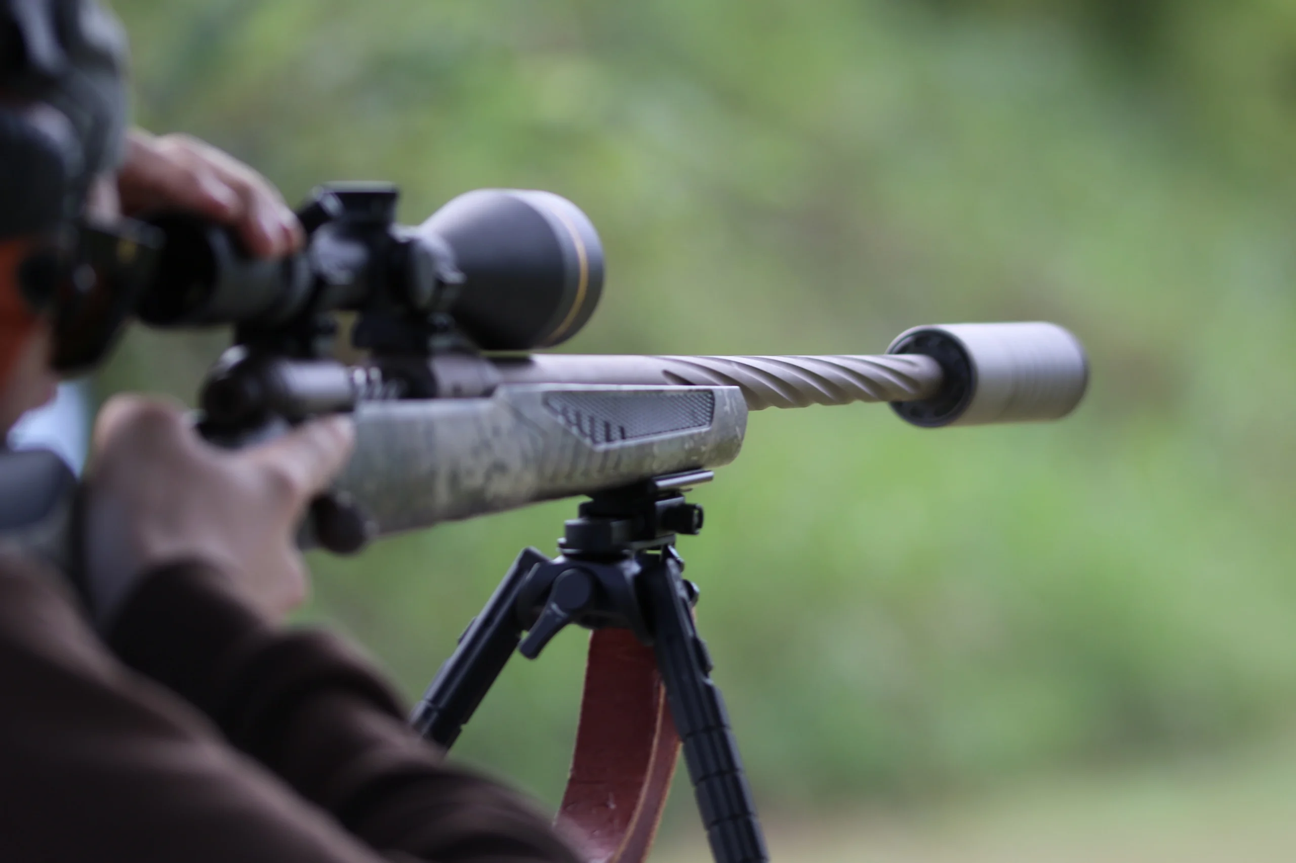 hunter looking through scope mounted to .308 Savage 110 High Country rifle suppressed with Silencerco Scythe Ti
