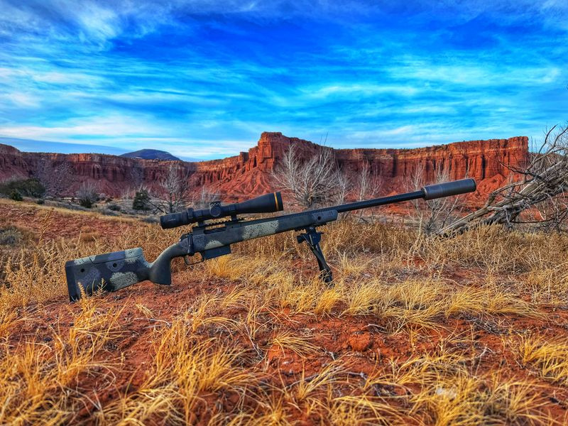 right side profile of Springfield Waypoint 2020 rifle, scoped, and suppressed with SilencerCo scythe-ti. Utah mountains in the background