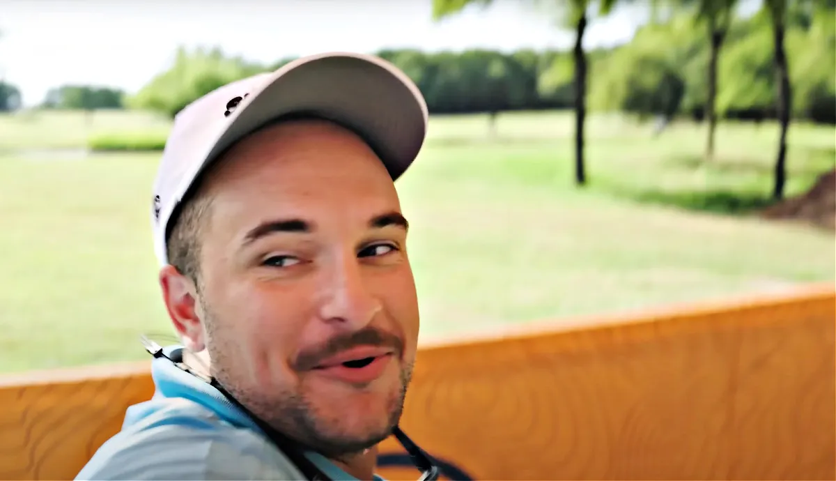 man grinning back at colleagues, saying "That's a hole in one, boys!"