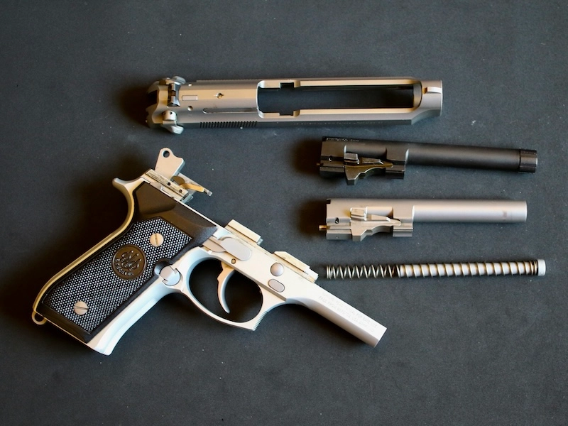 Berettta 92FS disassembled with factory barrel and SilencerCo threaded barrel