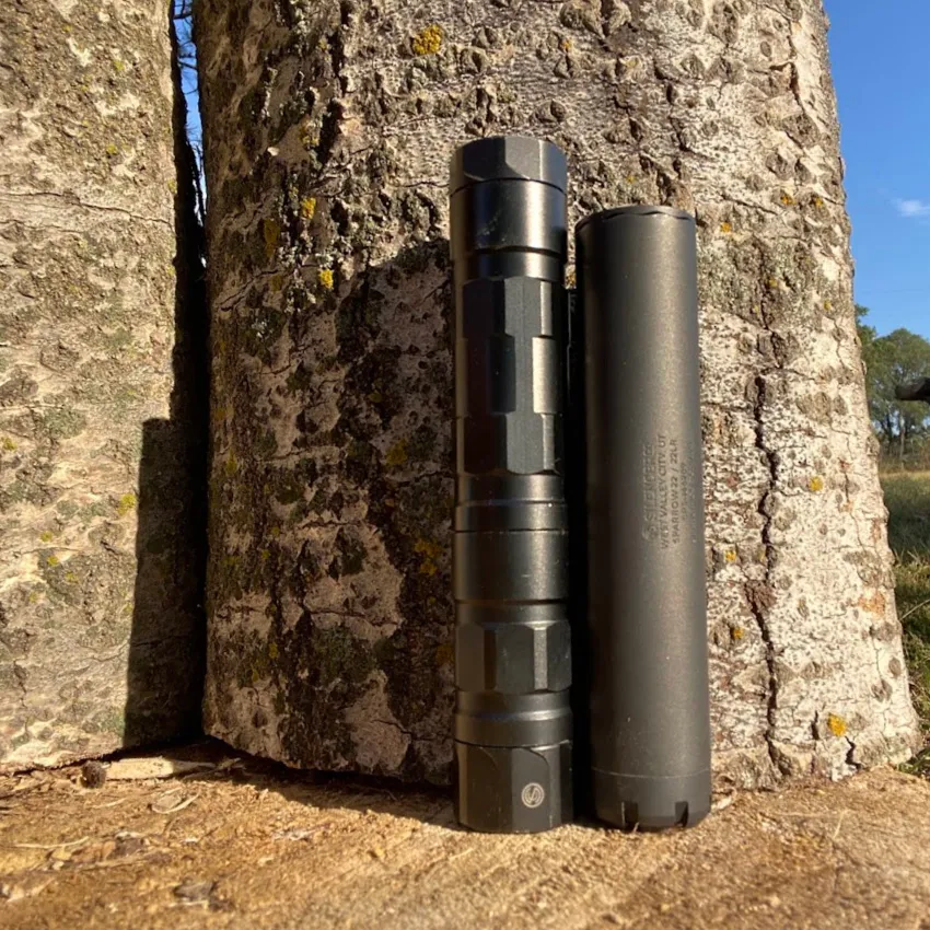 two rimfire suppressors on wood block