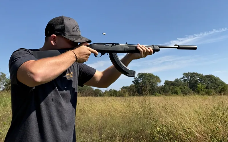 ruger 10/22 suppressor - man shooting rimfire rifle with silencerco Sparrow 22